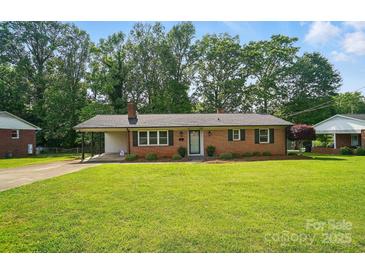 Charming brick home featuring a well-maintained lawn and covered carport at 137 Burton Hills Cir, Gastonia, NC 28054