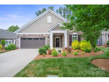 Charming home featuring manicured lawn, stone accents, attached two-car garage and covered front entryway at 16112 Lakeside Loop Ln, Cornelius, NC 28031