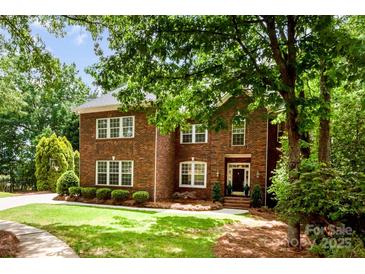Beautiful two-story brick home with a well-manicured lawn and mature trees at 1654 Scotch Pine Ln, Fort Mill, SC 29708