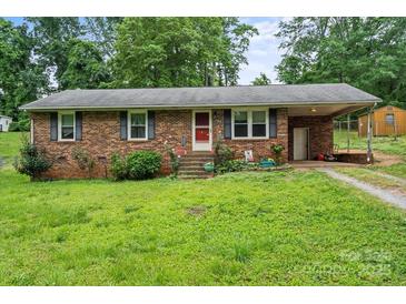 Charming brick home featuring a cozy front yard with mature landscaping and inviting curb appeal at 205 Pinehurst Dr, Kings Mountain, NC 28086