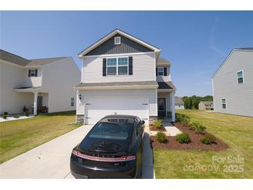Charming two-story home with a manicured lawn, a car, and an attached two-car garage at 2210 Transatlantic Ave, Charlotte, NC 28215
