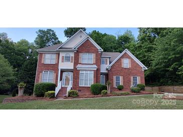 Charming two-story red brick home with manicured landscaping and a welcoming front porch at 3104 Highgate Dr, Fort Mill, SC 29715