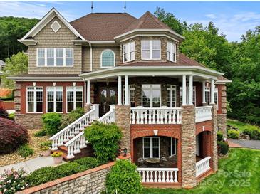 Stunning two-story home showcasing stone and brick accents, a charming porch, and meticulously landscaped surroundings at 6164 Dwayne Starnes Dr, Hickory, NC 28602