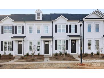 Charming townhome showcases a sleek white exterior, black shutters, and meticulously manicured landscaping at 8118 Jacey Ln # 21, Huntersville, NC 28078