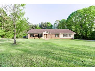 Ranch-style home featuring a brick facade, shutters, and a spacious lawn with mature trees at 856 Skyline Dr, Chester, SC 29706