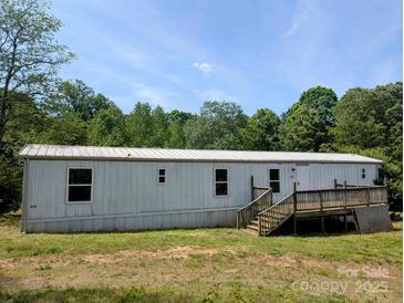 Exterior view of a single-story home featuring a wooden deck, modest landscaping, and a clean white exterior at 874 Old Home Place Way, Lincolnton, NC 28092