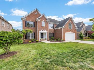 Charming two-story brick home featuring a well-manicured lawn and attached two car garage at 9923 Paradise Ridge Rd, Charlotte, NC 28277