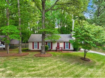 Charming single-story home with red shutters and a well-manicured lawn surrounded by mature trees at 10200 Cairnsmore Pl # 9, Mint Hill, NC 28227