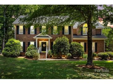 Charming two-story brick home with a well-manicured lawn and mature trees at 1261 Hawthorne Dr, Indian Trail, NC 28079