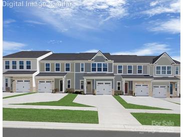 Charming townhome exteriors feature varied colors, one car garages, and well maintained lawns with inviting entryways at 1656 Respect Nw St, Concord, NC 28027