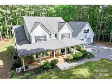 Charming two-story home with a large front porch and beautifully landscaped front yard and attached garage at 1956 Forest Ridge Dr, Stanley, NC 28164