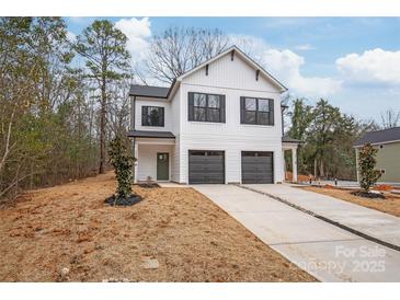 Charming two-story home featuring a white exterior, black accents, and a spacious driveway with a two-car garage at 2813 New Pineola Rd, Charlotte, NC 28208