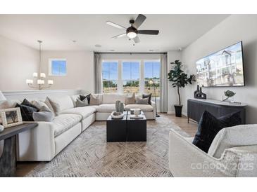Bright living room featuring a comfortable sectional sofa, modern decor, and large windows at 3128 Stelfox St, Charlotte, NC 28262