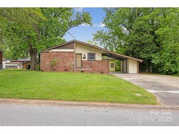 Charming single-story home featuring a brick facade, carport, and well-maintained lawn at 3828 Delgany Dr, Charlotte, NC 28215