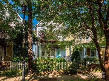 Charming two-story home featuring a quaint front yard and inviting porch with a bright teal front door at 541 Jetton St, Davidson, NC 28036