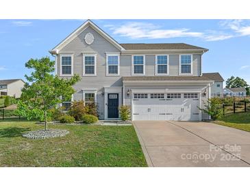 Charming two-story home features a well-maintained front yard, two-car garage, and inviting curb appeal at 7332 Newsome Sw Ct, Concord, NC 28025