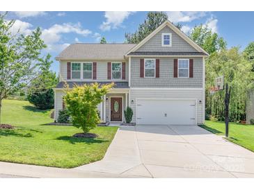 Charming two-story home with a well-manicured lawn and attached two-car garage at 1071 Bassett Way, Fort Mill, SC 29707