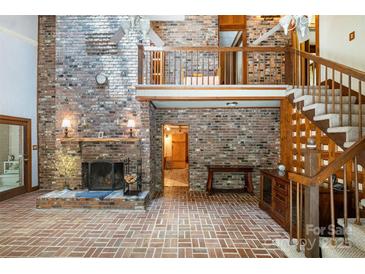Spacious living room with brick fireplace, brick floors, and second story balcony at 1160 Walton Pl, Salisbury, NC 28146