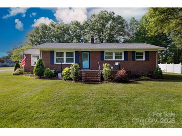 Charming red brick home with manicured lawn and landscaped garden beds, featuring a bright blue front door at 192 Bailey Ave, Rock Hill, SC 29732