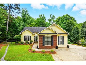 Charming home featuring manicured lawn and flowerbeds in a peaceful, wooded neighborhood at 2745 Stockwood Dr, Gastonia, NC 28056