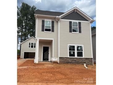 New two-story home featuring gray siding, stone accents, dark shutters, and a welcoming front entrance at 4017 Grommet Ct, Matthews, NC 28105