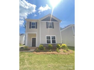 Charming two-story home featuring stone accents and a beautifully landscaped front yard on a sunny day at 4017 Grommet Ct, Matthews, NC 28105