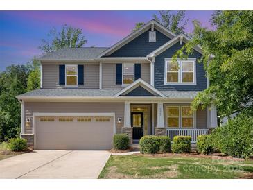 Charming two-story home with a large front yard, covered porch, and attached two-car garage at 5065 Watersail Way, Clover, SC 29710