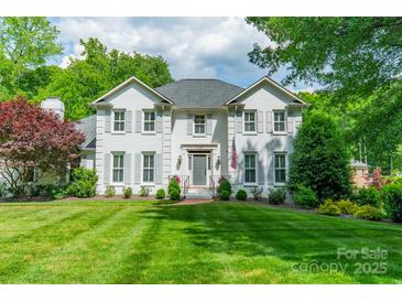 Charming two-story white brick home with lush lawn and manicured landscaping at 5135 Winding Brook Rd, Charlotte, NC 28226