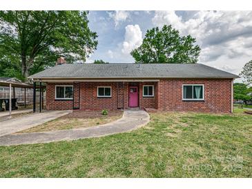 Charming brick home with a pink front door and well-maintained lawn at 85 Sw Myrtle Sw Ave, Concord, NC 28025