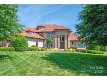 Stately brick home with a manicured lawn and lush landscaping in a desirable neighborhood at 8904 Woodhall Lake Dr, Waxhaw, NC 28173