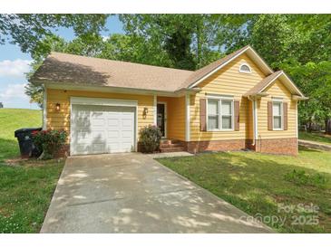 Charming yellow home with attached garage, brick accents, and well-maintained landscaping at 11701 Brockley Ct, Charlotte, NC 28215