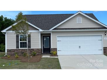 Charming single-Gathering home featuring stone accents, a white garage door, and a well-manicured front yard at 1554 Doran Ter, Richburg, SC 29729