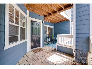 Charming entrance with wooden door and covered porch featuring outdoor seating area at 2209 Sumner Green Ave # M, Charlotte, NC 28203