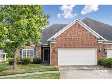 Charming home featuring a brick and stone facade, an attached two-car garage, and a well-manicured lawn at 2910 Lake James Ct, Monroe, NC 28110