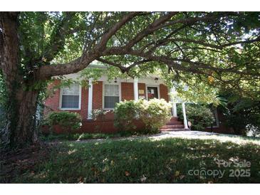 Charming brick home with a front porch, framed by mature tree with lots of shade and curb appeal at 5127 Murrayhill Rd, Charlotte, NC 28210