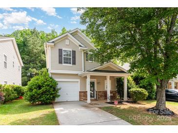 Charming two-story home features a welcoming front porch, attached garage, and well-maintained landscaping at 516 Tribune Dr, Charlotte, NC 28214