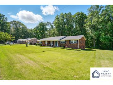 Charming single-story brick home features a manicured lawn and a welcoming covered front porch at 707 Hester Dr, Dallas, NC 28034