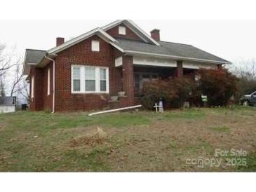 Charming brick home with a covered porch and a spacious front yard at 1040 Nc 90 W Hwy, Taylorsville, NC 20681