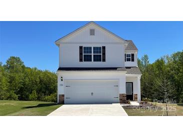 Two-story home boasts a clean white facade, complemented by a two car garage and well-manicured lawn at 1546 Doran Ter, Richburg, SC 29729