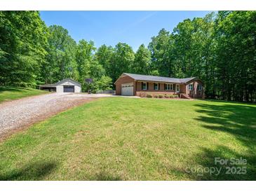 Brick home with an attached garage and separate storage building on a spacious lot with mature trees at 174 Buena Vale Dr, Gastonia, NC 28056