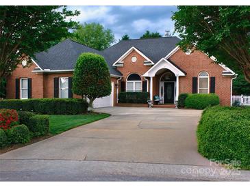 Charming brick home boasts a well-manicured lawn, mature trees, and a long driveway to the garage and front entrance at 2289 Veery Ln # 23, Rock Hill, SC 29732