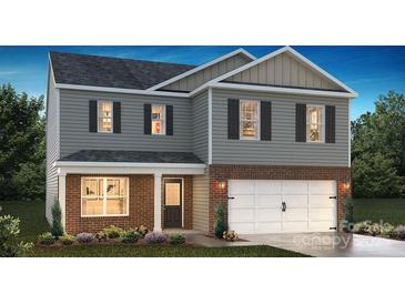 Two-story home with gray siding, brick accents, a two car garage, and a well-manicured front lawn at 3905 Coleman Dr, Charlotte, NC 28215