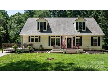 Charming home featuring dormer windows, black shutters, a cozy porch and a lush green front lawn at 7648 Forest Oak Dr, Denver, NC 28037