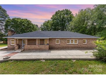 Charming brick home with a classic design and mature trees creating a serene and inviting atmosphere at 103 Sadler Rd, Mount Holly, NC 28120