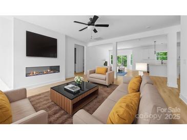 Bright living room boasts a fireplace, ceiling fan, and neutral decor throughout the open floor plan at 13109 Homewood Dr, Charlotte, NC 28262