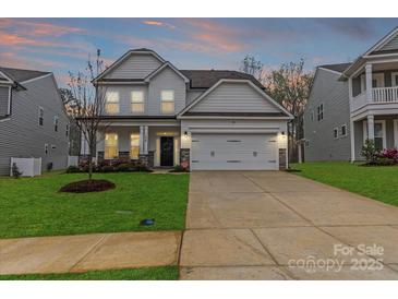 Charming two-story home features a well-manicured lawn, two-car garage, and inviting front porch at 154 Cotton Field Dr, Statesville, NC 28677