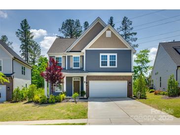 Charming two-story home featuring a two-car garage, brick accents, and a beautifully landscaped front yard at 1540 Striped Bass Ln, Clover, SC 29710
