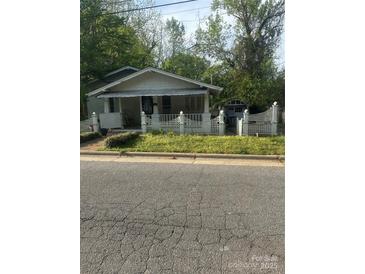 Charming bungalow-style house with a cozy front porch and white picket fence at 216 Maple St, Statesville, NC 28677