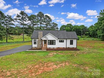 Charming white cottage-style home with stone chimney, black trim, and lush green lawn at 456 Rainbow Cir, Clover, SC 29710
