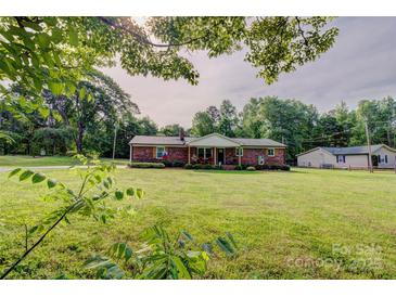 Charming brick ranch home with a large, well-maintained lawn and mature trees providing shade at 1009 High Shoals Rd, Lincolnton, NC 28092